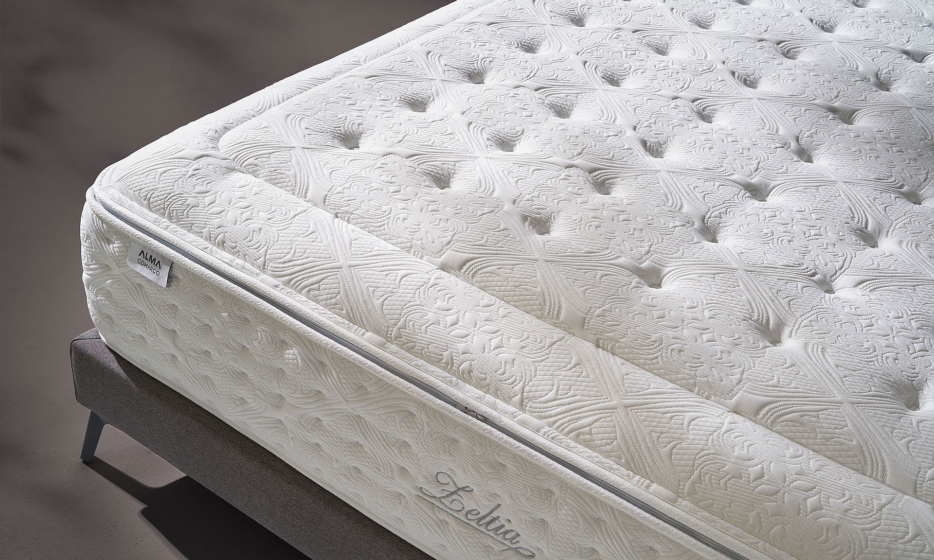 Photo présentant un zoom sur un matelas de haute qualité blanc, ainsi des motifs de fleur et de formes géométrique.